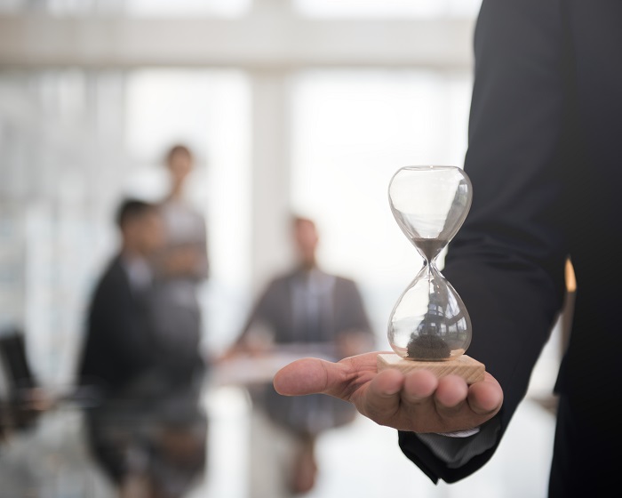 Businessman holding an hour glass, signifies the importance of being on time